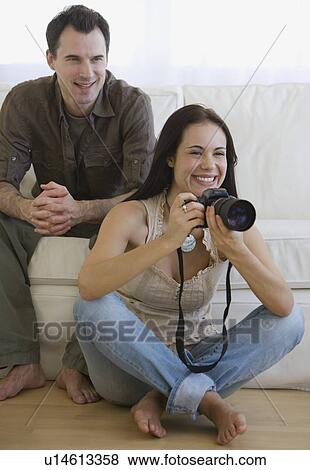 Stock Photo - Woman holding camera next to face. Fotosearch
