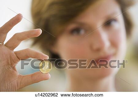 Stock Image - Woman holding coin. Fotosearch