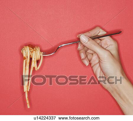 Woman holding forkful of pasta View Large Photo Image Stock Photo - Woman holding forkful of pasta. Fotosearch