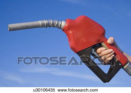 Stock Photography - Woman holding gas pump nozzle. Fotosearch