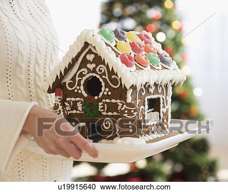 Woman holding gingerbread house on tray View Large Photo Image Stock Image - Woman holding gingerbread house on tray. Fotosearch