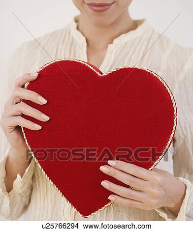 Picture - Woman holding heart shaped box. Fotosearch