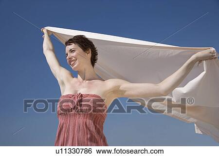 Woman holding sheet in wind View Large Photo Image Stock Photograph - Woman holding sheet in wind. Fotosearch