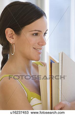 Stock Image - Woman holding stack of school books. Fotosearch