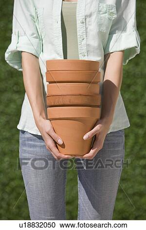 Woman holding stack of terracotta pots View Large Photo Image Stock Image - Woman holding stack of terracotta pots. Fotosearch