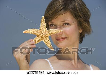 Stock Image - Woman holding starfish. Fotosearch