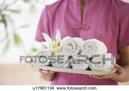 Picture - Woman holding tray of rolled towels. Fotosearch