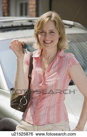 Stock Photograph - Woman holding up car keys. Fotosearch