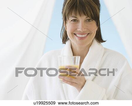 Woman in bathrobe holding juice View Large Photo Image Stock Photo - Woman in bathrobe holding juice. Fotosearch
