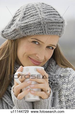 Woman in hat and sweater holding coffee mug View Large Photo Image Stock Photo - Woman in hat and sweater holding coffee mug. Fotosearch