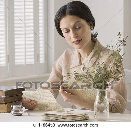 Stock Image - Woman in vintage clothing reading letter. Fotosearch