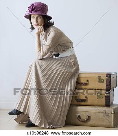 Woman in vintage clothing sitting on suitcases View Large Photo Image Stock Photo - Woman in vintage clothing sitting on suitcases. Fotosearch