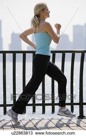 Woman jogging in urban area View Large Photo Image Stock Image - Woman jogging in urban area. Fotosearch