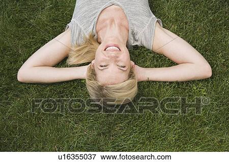 Woman laying in grass View Large Photo Image Stock Photo - Woman laying in grass. Fotosearch