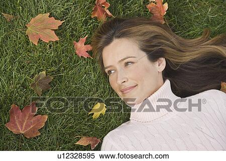 Stock Photography - Woman laying in grass. Fotosearch