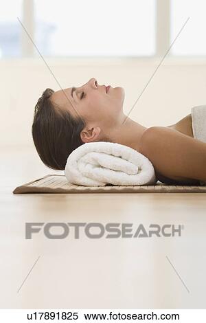 Woman laying on mat with rolled towel under neck View Large Photo Image Stock Photography - Woman laying on mat with rolled towel under neck. Fotosearch