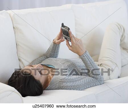 Woman laying on sofa using electronic organizer View Large Photo Image Stock Image - Woman laying on sofa using electronic organizer. Fotosearch