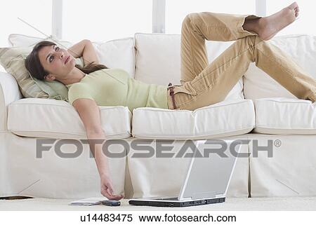 Woman laying on sofa with laptop on floor View Large Photo Image Stock Photography - Woman laying on sofa with laptop on floor. Fotosearch