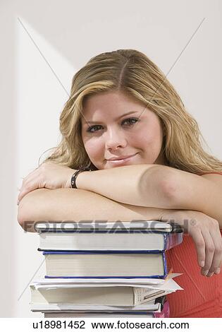 Stock Image - Woman leaning on stack of books. Fotosearch