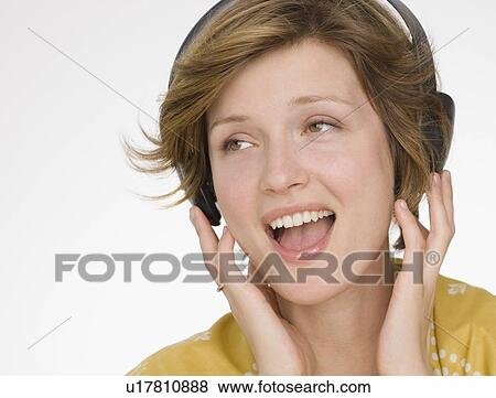 Stock Photo - Woman listening to headphones. Fotosearch