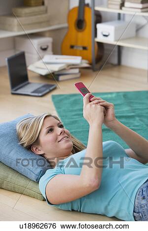 Stock Photograph - Woman looking at cell phone. Fotosearch