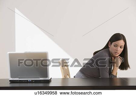 Woman looking over shoulder at laptop View Large Photo Image Stock Photo - Woman looking over shoulder at laptop. Fotosearch