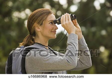 Woman looking through binoculars View Large Photo Image Stock Photo - Woman looking through binoculars. Fotosearch