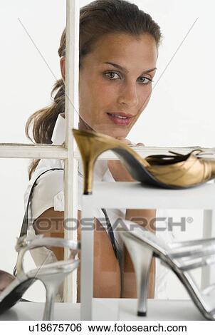 Woman looking through window at shoes on display View Large Photo Image Stock Photograph - Woman looking through window at shoes on display. Fotosearch