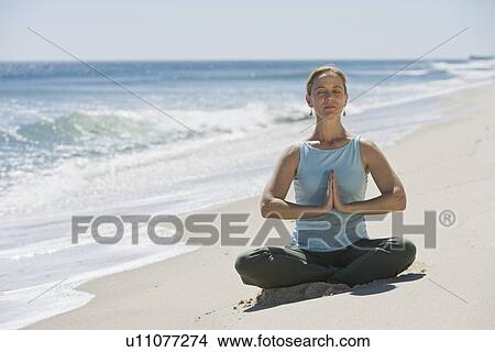 Woman meditating at beach View Large Photo Image Picture - Woman meditating at beach. Fotosearch