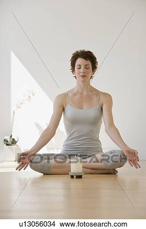 Woman meditating next to candle View Large Photo Image Picture - Woman meditating next to candle. Fotosearch