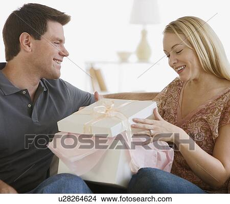 Woman opening gift from husband View Large Photo Image Picture - Woman opening gift from husband. Fotosearch