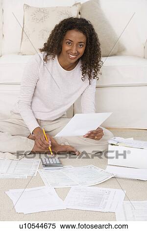 Stock Photography - Woman paying bills on floor. Fotosearch