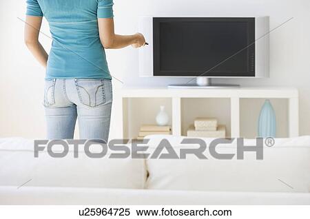 Woman pointing remote control at television View Large Photo Image Stock Photography - Woman pointing remote control at television. Fotosearch