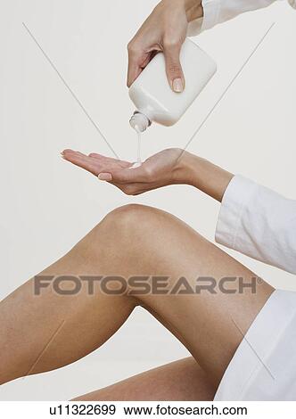 Woman pouring lotion into hand View Large Photo Image Stock Photo - Woman pouring lotion into hand. Fotosearch