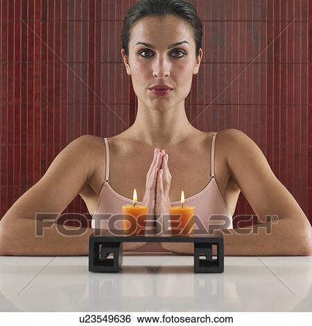 Woman praying behind tray with lit candles View Large Photo Image Stock Photograph - Woman praying behind tray with lit candles. Fotosearch