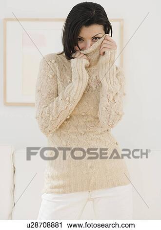 Woman pulling sweater over face View Large Photo Image Stock Image - Woman pulling sweater over face. Fotosearch