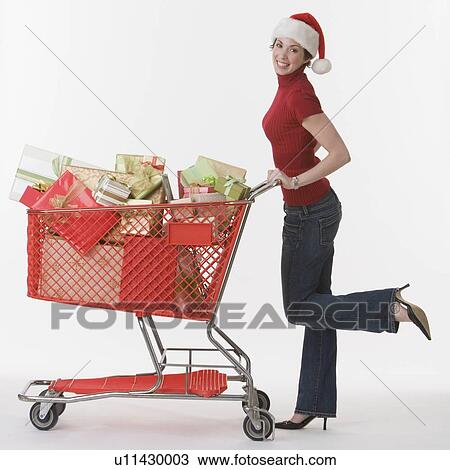 Woman pushing shopping cart of gifts View Large Photo Image Stock Image - Woman pushing shopping cart of gifts. Fotosearch