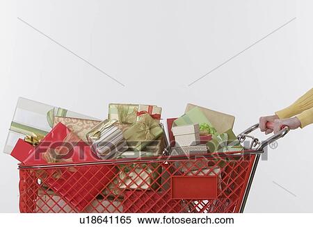 Stock Photography - Woman pushing shopping cart of gifts. Fotosearch