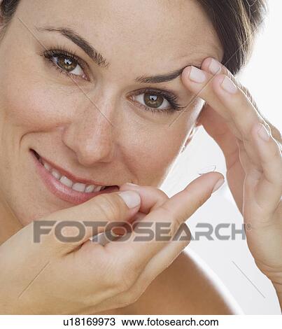 Stock Image - Woman putting in contact lens. Fotosearch