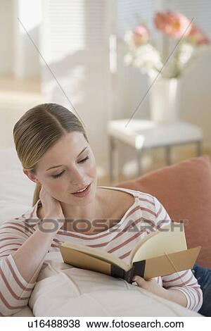 Woman reading on sofa View Large Photo Image Stock Photo - Woman reading on sofa. Fotosearch