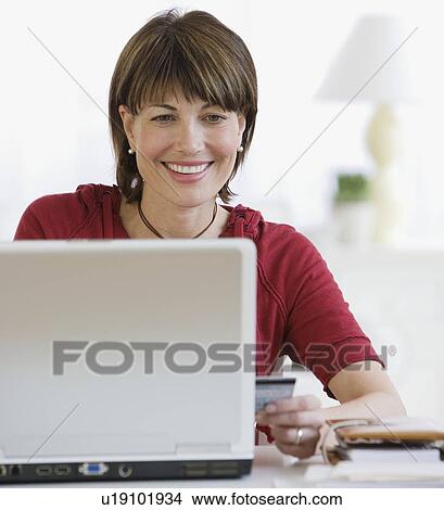 Picture - Woman shopping online. Fotosearch