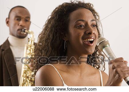 Woman singing into microphone View Large Photo Image Stock Photo - Woman singing into microphone. Fotosearch