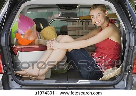 Stock Image - Woman sitting in back of car. Fotosearch