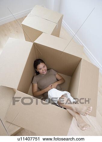 Woman sitting in empty moving box View Large Photo Image Stock Image - Woman sitting in empty moving box. Fotosearch