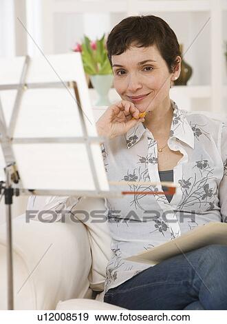Woman sitting next to sheet music on stand View Large Photo Image Stock Photo - Woman sitting next to sheet music on stand. Fotosearch