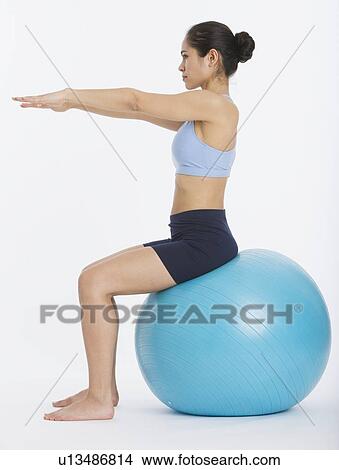 Picture - Woman sitting on exercise ball. Fotosearch