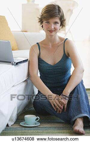 Stock Photo - Woman sitting on floor with coffee. Fotosearch