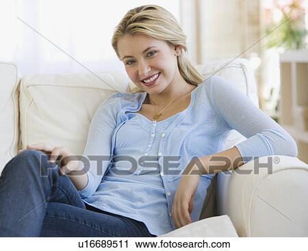 Woman sitting on sofa View Large Photo Image Stock Image - Woman sitting on sofa. Fotosearch