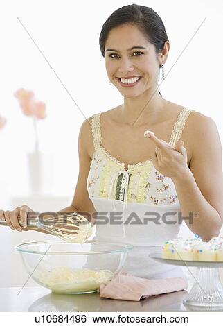 Stock Photograph - Woman stirring batter in kitchen. Fotosearch