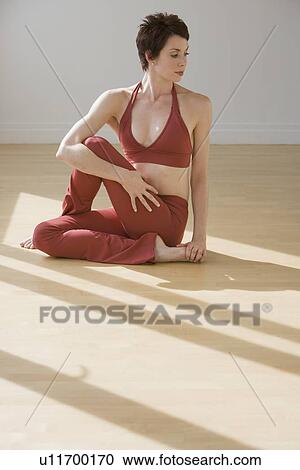 Stock Image - Woman stretching on floor. Fotosearch